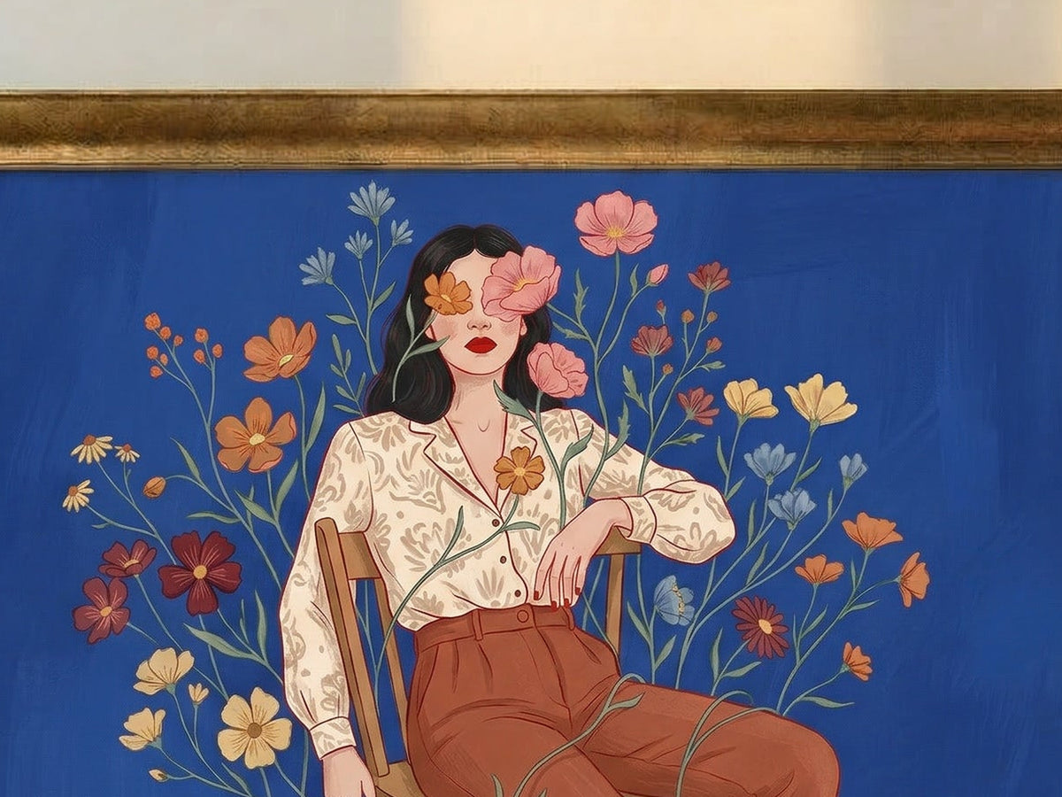 Top edge of a Royal Gold frame over a woman in a cream blouse and rust trousers, pink flowers covering her eyes